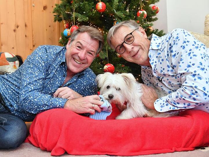 Patrick Lindner (l) und sein Lebensgefährte Peter Schäfer mit ihrem Hund Obelix.