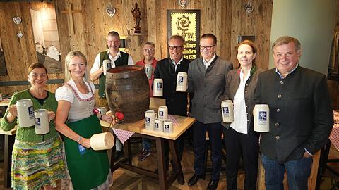 Monika Gruber (2. v. l.) probt das Anzapfen im Wirtshaus zum Stiftl gemeinsam mit (v. l.) der künstlerischen Leiterin Traudi Siferlinger, den Augustiner-Braumeistern Thomas Reiter und Dieter Adam-Czyk, den Augustiner-Geschäftsführern Werner Mayer und Martin Leibhard sowie dem Wirtspaar Christine und Lorenz Stiftl.