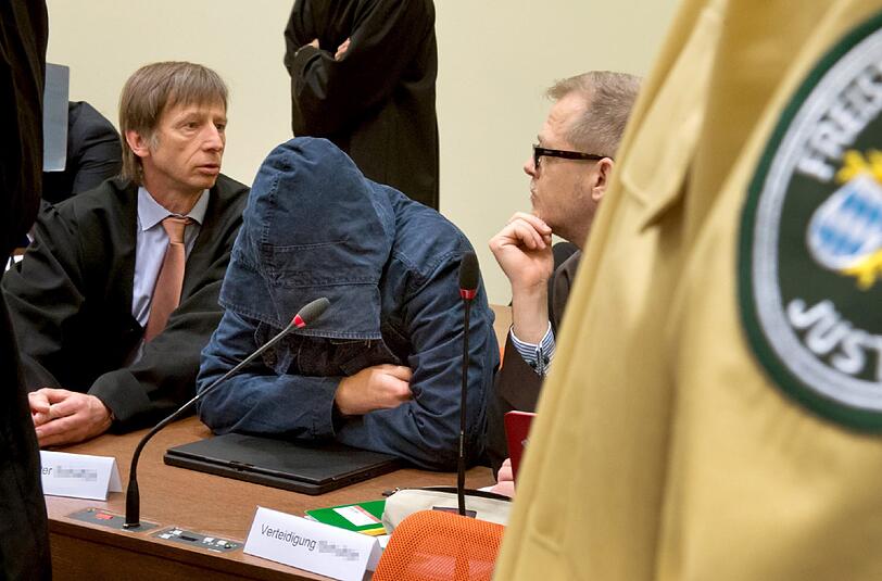 Der Angeklagte Carsten S. (M) sitzt am 05.06.2013 im Gerichtssaal in München zwischen seinen Anwälten Johannes Pausch (l) und Jacob Hösl (r) und verbirgt sein Gesicht hinter einer Kapuze.