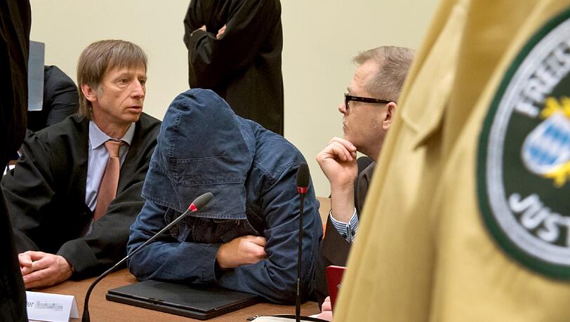 Der Angeklagte Carsten S. (M) sitzt am 05.06.2013 im Gerichtssaal in München zwischen seinen Anwälten Johannes Pausch (l) und Jacob Hösl (r) und verbirgt sein Gesicht hinter einer Kapuze. Der Angeklagte Carsten S. (M) sitzt am 05.06.2013 im Gerichtssaal in München zwischen seinen Anwälten Johannes Pausch (l) und Jacob Hösl (r) und verbirgt sein Gesicht hinter einer Kapuze.