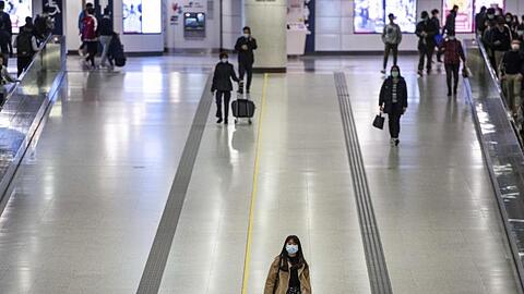 Pendler in Hongkong tragen Mundschutz in einer U-Bahnstation.