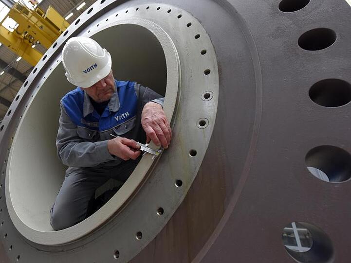 Ein Arbeiter vermisst Teile einer Turbine. Foto: Stefan Puchner/dpa/Archivbild