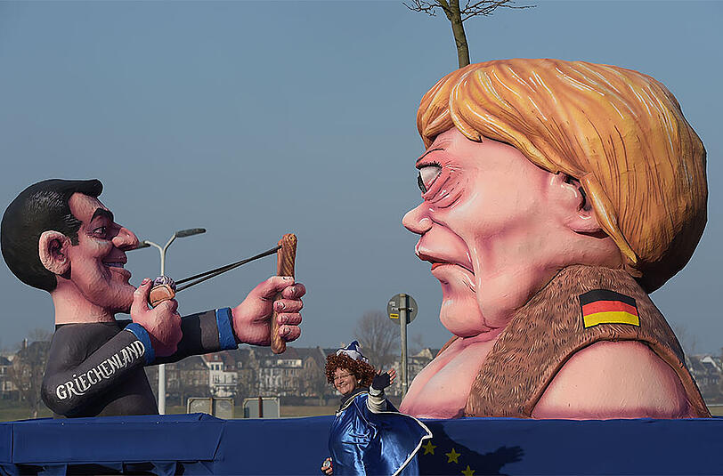 Düsseldorf: Der Motivwagen zeigt den griechischen Ministerpräsidenten Alexis Tsipras, der die Bundeskanzlerin Angela Merkel mit einer Steinschleuder abschießt.