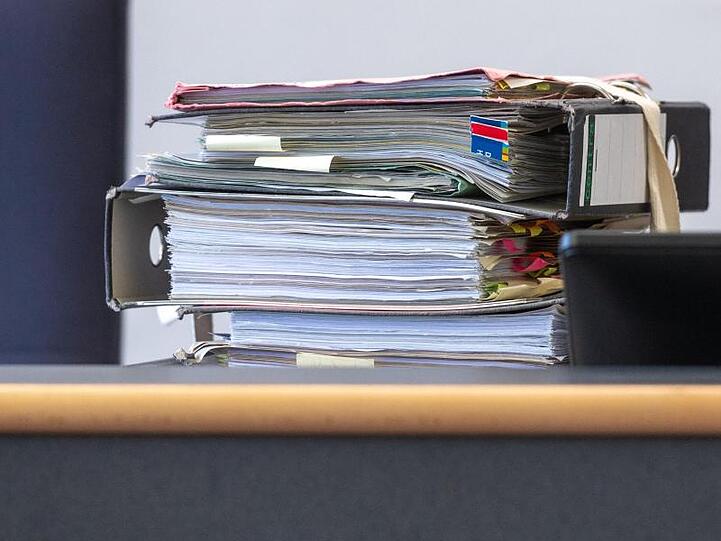 Gerichtsakten liegen in einem Verhandlungssaal auf dem Tisch. Foto: Armin Weigel/dpa /Archivbild