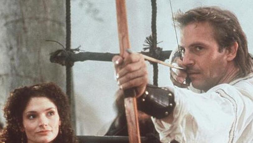 Die Treffsicherheit Robin Hoods (Kevin Costner, r.) ist im ganzen Land berühmt. Einzig die schöne Marian (Mary Elizabeth Mastrantonio, l.) verunsichert die Hand des Helden Die Treffsicherheit Robin Hoods (Kevin Costner, r.) ist im ganzen Land berühmt. Einzig die schöne Marian (Mary Elizabeth Mastrantonio, l.) verunsichert die Hand des Helden
