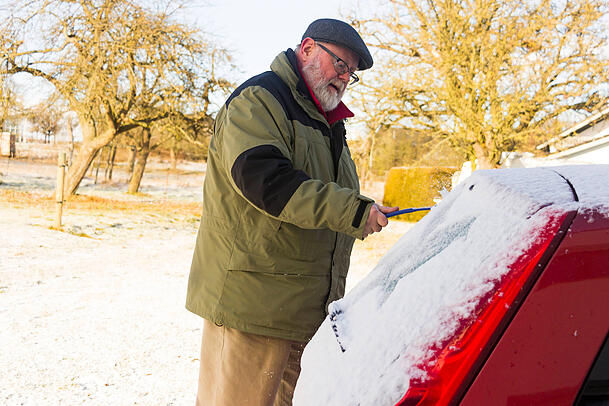 Ein Mann befreit seinen Wagen vom Schnee. Auch das Dach und die Motorhaube müssen freigeräumt sein. Ein Mann befreit seinen Wagen vom Schnee. Auch das Dach und die Motorhaube müssen freigeräumt sein.