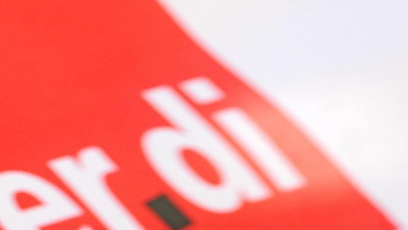 Ein Mann hat am bei einem Warnstreik vor dem roten Verdi-Logo eine Trillerpfeife im Mund. Foto: Patrick Seeger/dpa/Archivbild
