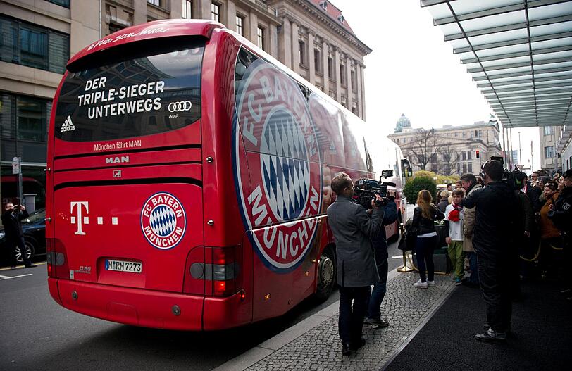 Müde Bayern-Spieler schleppen sich nach einer kurzen Nacht zum Mannschaftsbus.