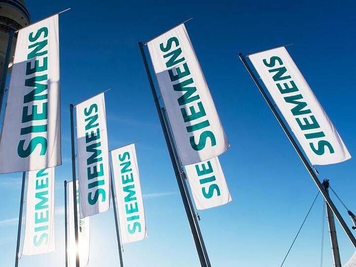 Siemens-Fahnen vor der Hauptverwaltung in München. Foto: Peter Kneffel/dpa/Archivbild