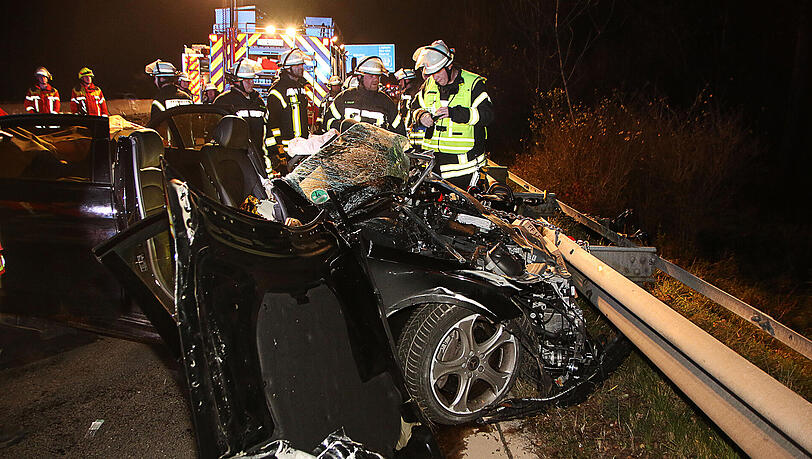 Feuerwehrleute stehen am 24.11.2017 auf der Autobahn 8 bei Leipheim (Bayern) hinter einem zerstörten Fahrzeug. Feuerwehrleute stehen am 24.11.2017 auf der Autobahn 8 bei Leipheim (Bayern) hinter einem zerstörten Fahrzeug.