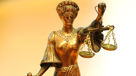 Eine goldfarbene Justitia-Figur mit verbundenen Augen und Waage in der Hand. (Symbolbild)