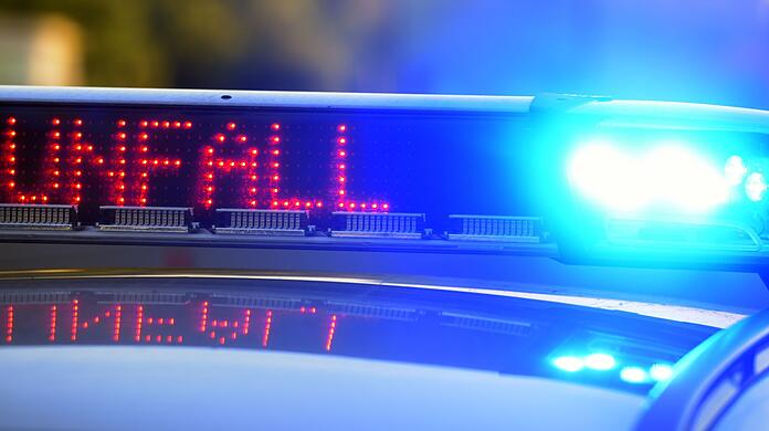 Auf einem Polizeifahrzeug warnt eine Leuchtschrift vor einer Unfallstelle.
