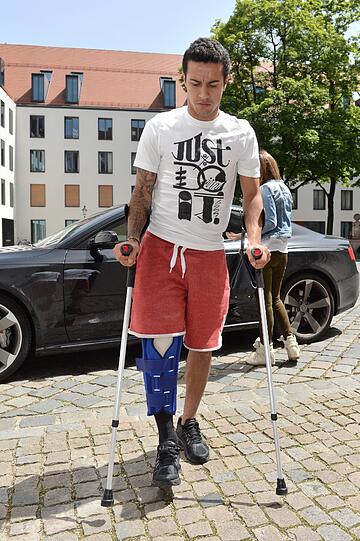 Dick einbandagiert: Thiago nach seiner Knie-OP auf dem Weg zu Bayern-Doc Müller-Wohlfahrt.