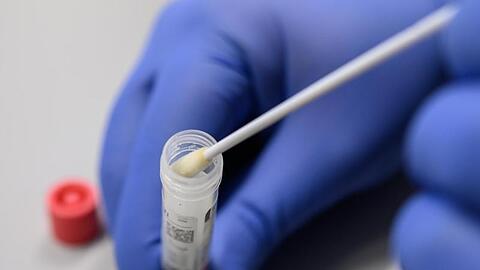 Ein Mann zeigt einen Abstrich für das Testverfahren auf das Virus SARS-CoV-2. Foto: Sebastian Gollnow/dpa/Symbolbild