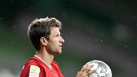 Bayern Münchens Thomas Müller hält einen Fußball in der Hand. Foto: Martin Meissner/AP-Pool/dpa