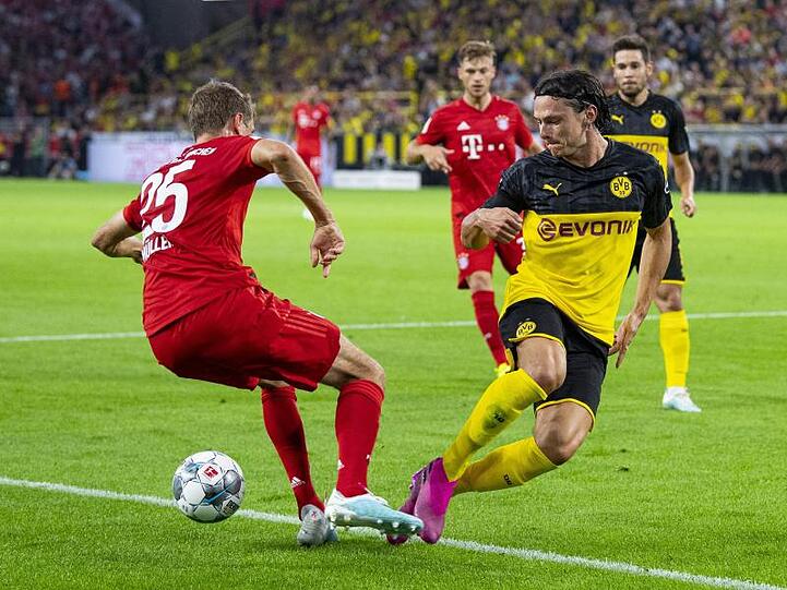 Treffen im Bundesliga-Topspiel aufeinander: Dortmunds Nico Schulz (r) und Bayerns Thomas Müller.