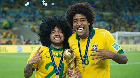 Mattenvergleich: Brasiliens Dani Alves (l.) macht einen auf Dante. Der Bayern-Star mit der echten Lockenpracht findet sein Double prima. Foto: firo/AK