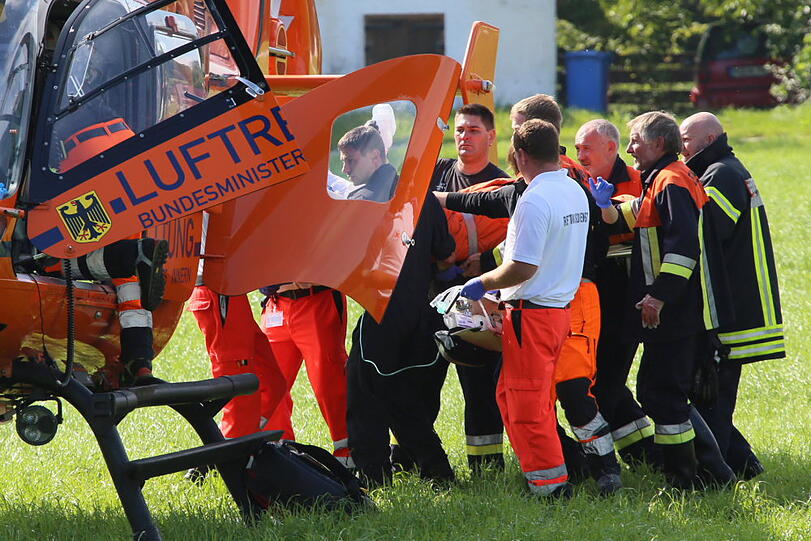 Heftiger Unfall bei Mühldorf: Ein junger Mann stürzte mit seinem Motorrad und geriet unter den Anhänger eines Traktors.