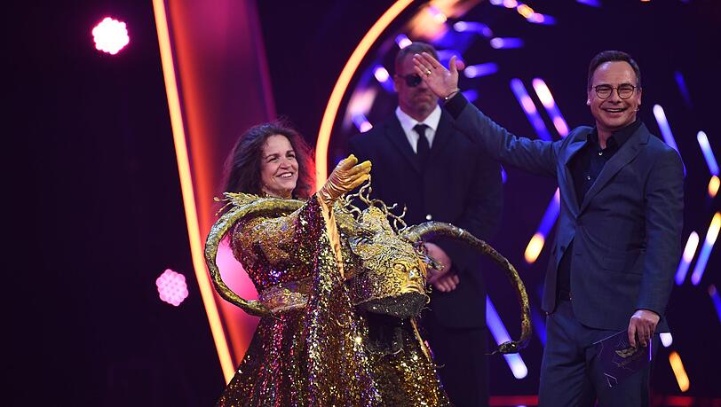 Rebecca Immanuel, Schauspielerin, steht als enttarnte Figur "Die Göttin" in der Prosieben-Show "The Masked Singer" neben Moderator Matthias Opdenhövel auf der Bühne. Rebecca Immanuel, Schauspielerin, steht als enttarnte Figur "Die Göttin" in der Prosieben-Show "The Masked Singer" neben Moderator Matthias Opdenhövel auf der Bühne.