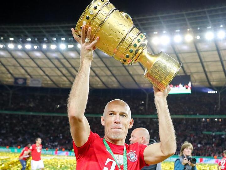 Spieler Arjen Robben von Bayern reckt den Pokal in die Höhe und bedankt sich nach dem Spiel bei den Fans. Foto: Jan Woitas/Archivbild