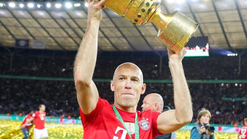 Spieler Arjen Robben von Bayern reckt den Pokal in die Höhe und bedankt sich nach dem Spiel bei den Fans. Foto: Jan Woitas/Archivbild