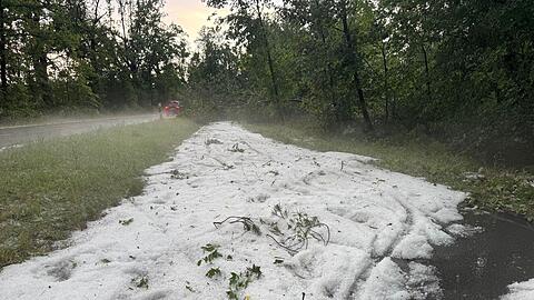 Nach einem starken Gewitter liegt Hagel auf einem Radweg in Erlangen.