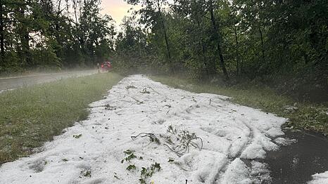 Nach einem starken Gewitter liegt Hagel auf einem Radweg in Erlangen.