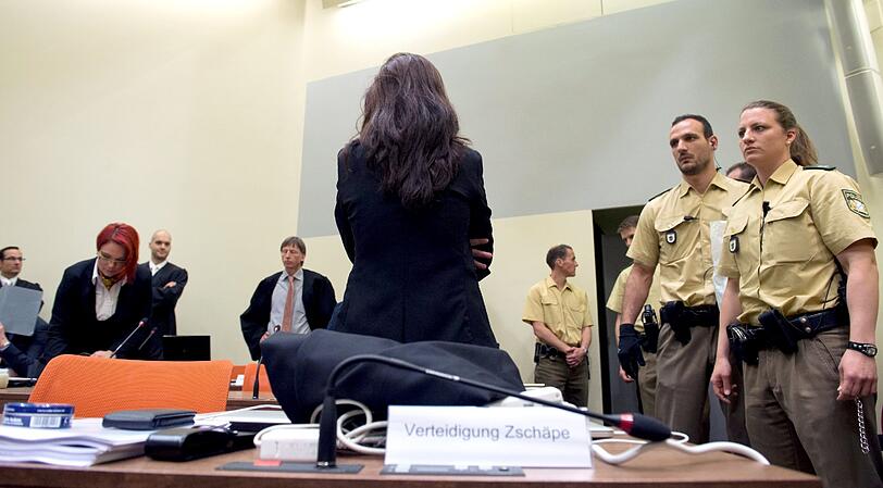 Die Angeklagte Beate Zschäpe (Mitte) steht zum Prozessauftakt im Gerichtssaal in München.