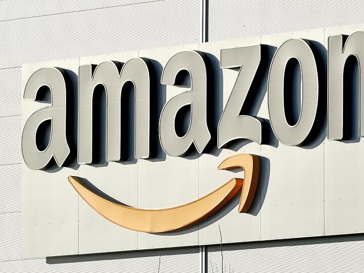 Logo und Schriftzug von Amazon an einem Paketzentrum des Online-Händlers. Foto: Holger Hollemann/Archiv