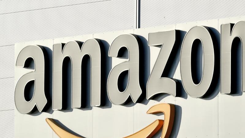Logo und Schriftzug von Amazon an einem Paketzentrum des Online-Händlers. Foto: Holger Hollemann/Archiv