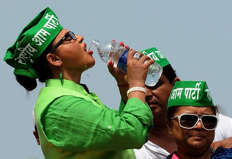 Parlaments-Wahlen in Indien: Die Bollywood-Schauspielerin Rakhi Sawant kandidiert für die Rashtriya-Aam-Partei und nimmt beim Wahlkampf erstmal einen kräftigen Schluck Wasser. Die Chili-förmigen Ohrringe trägt sie übrigens weil die Chili-Schote das Symbol ihrer Partei ist.