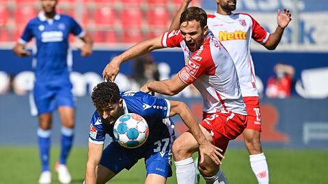 Karlsruhes Fabio Kaufmann (l) versucht den Ball vor Regensburgs Benedikt Gimber zu behaupten.