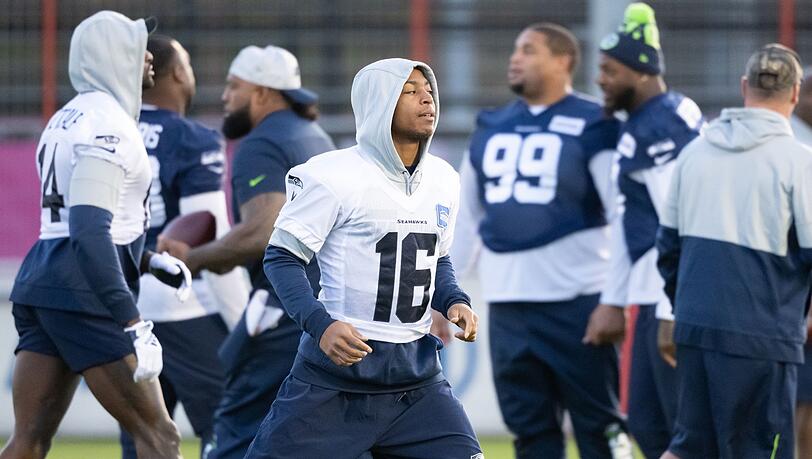Tyler Lockett steht mit seinen Mitspielern auf dem Trainingsgelände.