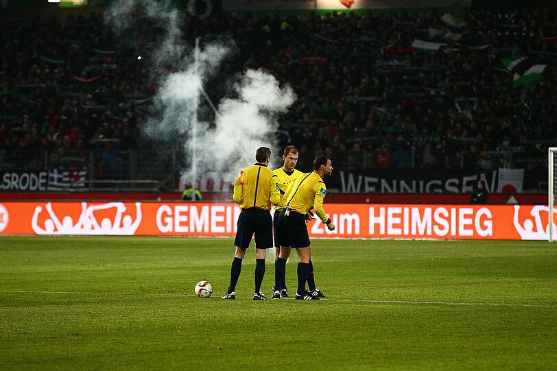 Scheußliche Szenen: Wolfsburger Fans zündeten Leuchtraketen - eine traf sogar die Auswechselbank von Hannover.