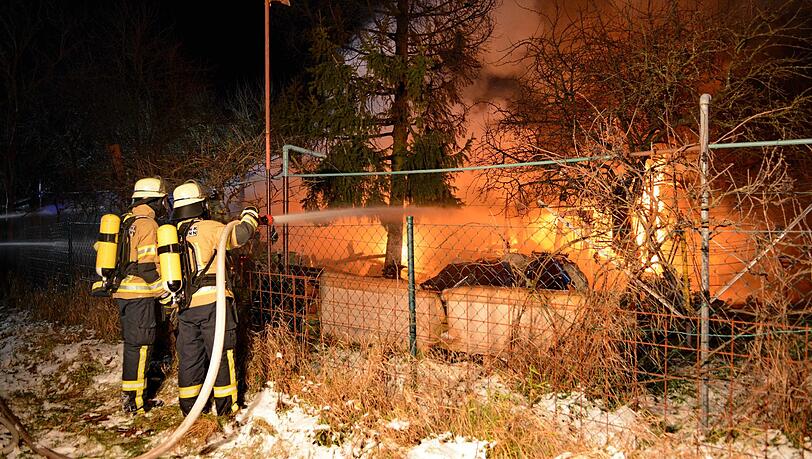 Feuerwehrleute löschen in Langenzenn (Bayern) den Brand der Gartenhütte. Feuerwehrleute löschen in Langenzenn (Bayern) den Brand der Gartenhütte.