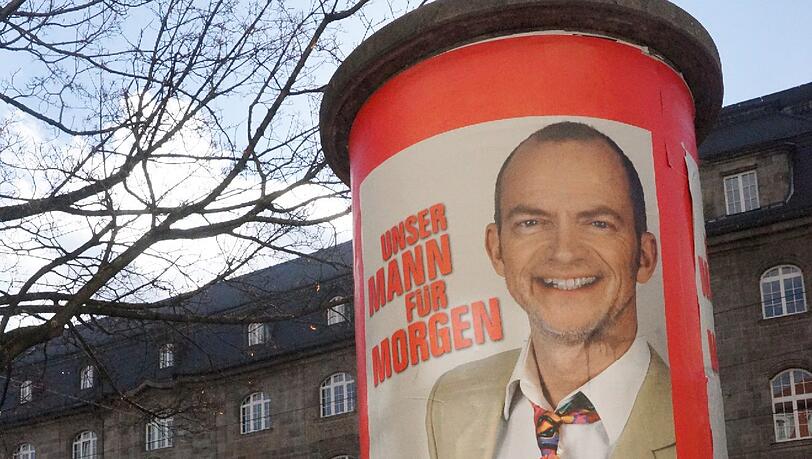 Für die wirbt der Sender jetzt mit einem Wahlplakat, auf dem Mike Thiel mit schriller Krawatte und Drei-Tage-bart zu sehen ist. Für die wirbt der Sender jetzt mit einem Wahlplakat, auf dem Mike Thiel mit schriller Krawatte und Drei-Tage-bart zu sehen ist.