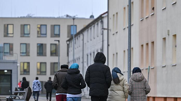Migranten gehen über das Gelände der Zentralen Erstaufnahmeeinrichtung für Asylbewerber des Landes Brandenburg in Eisenhüttenstadt.