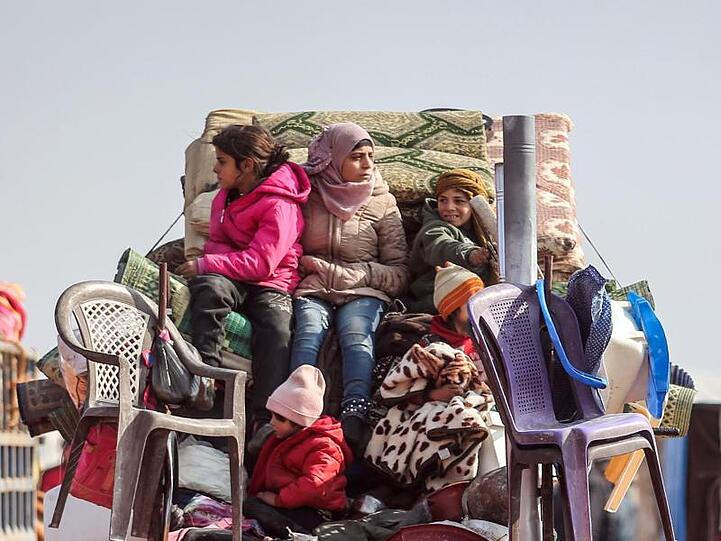 Flucht aus Idlib: Kinder sitzen auf der Ladefläche eines Kleintransporters auf den Habseligkeiten ihrer Familie.