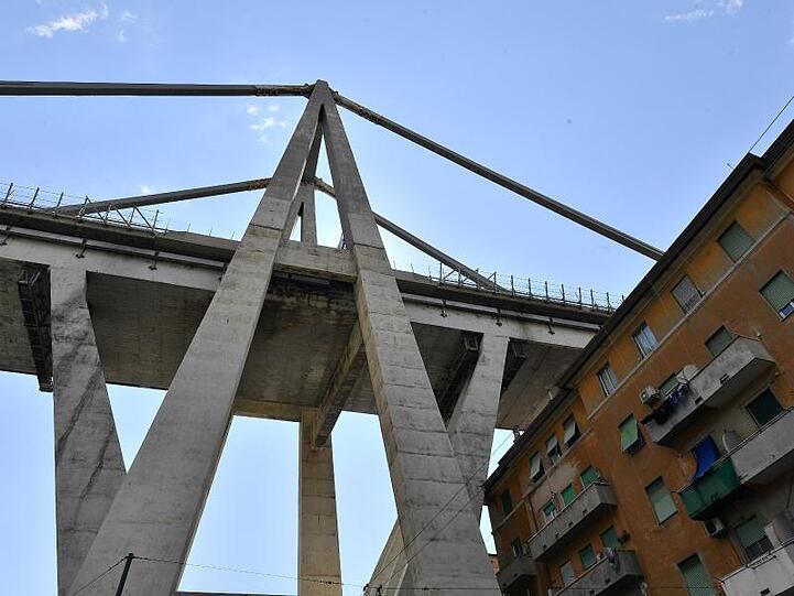 Blick auf die teilweise eingestürzte Morandi-Autobahnbrücke über einem evakuierten Wohnhaus.