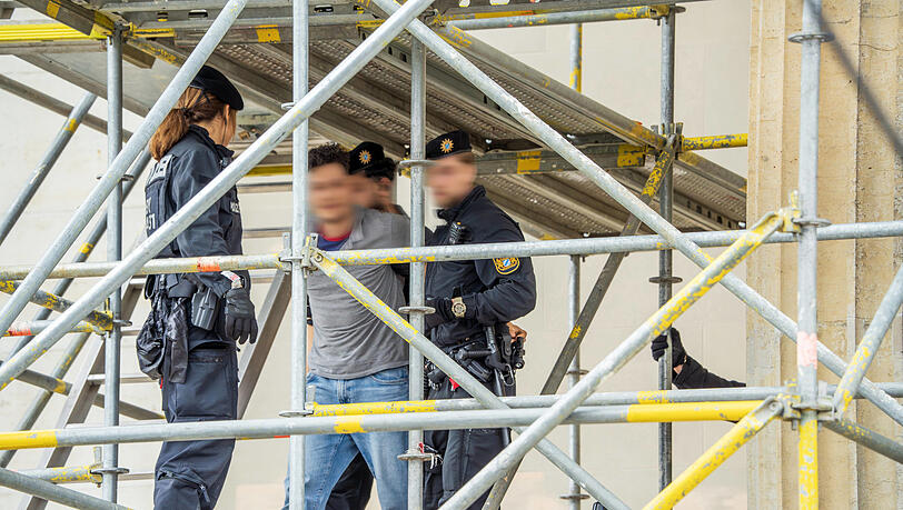 Als die beiden Identitären herunterklettern, nimmt sie die Polizei fest. Kurz vorher segelte das Banner herunter. Als die beiden Identitären herunterklettern, nimmt sie die Polizei fest. Kurz vorher segelte das Banner herunter.