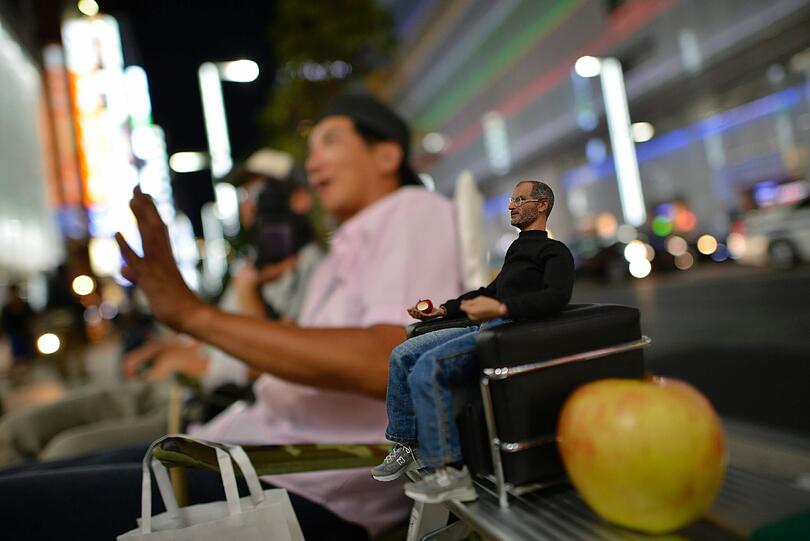 Ein Apple-Fan in Tokio wartet mit einer kleinen Figur von Steve Jobs (Mitgründer von Apple) auf den Verkaufsstart des iPhone 5s.