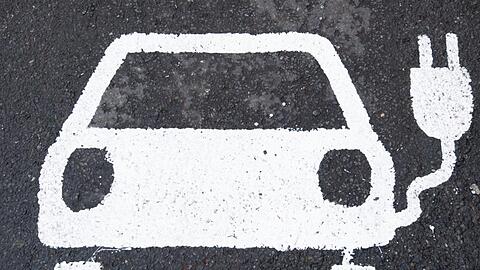 Ein Symbol für ein Elektroauto markiert einen Parkplatz neben einer E-Ladesäule. Foto: Julian Stratenschulte/dpa/Archivbild