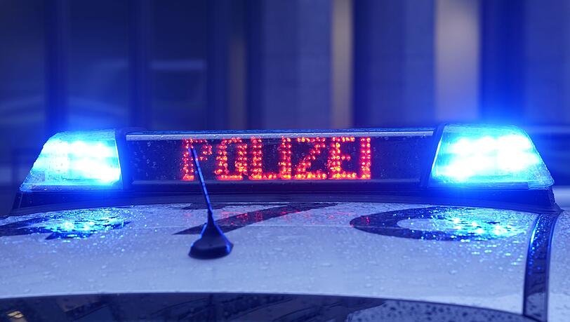 Der Schriftzug "Polizei" ist neben dem Blaulicht auf dem Dach eines Polizeiautos zu lesen.
