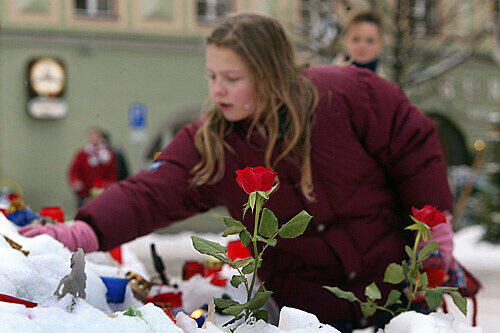Ein Mädchen greift am 4. Januar 2006 in der Bad Reichenhaller Innenstadt nach einer Kerze.