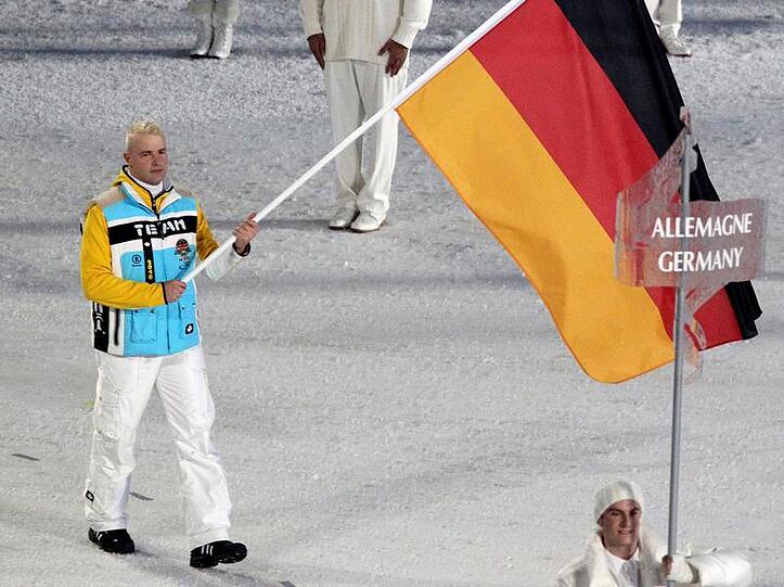Bei der Eröffnung war Andre Lange stolzer Fahnenträger der deutschen Mannschaft. Sein Start im Zweierbob gerät nun in Gefahr.