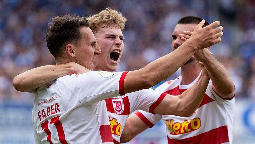Konrad Faber (l-r), Torschütze Dominik Kother und Rasim Bulic von Regensburg jubeln über das Tor zum 1:2.