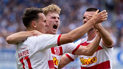 Konrad Faber (l-r), Torschütze Dominik Kother und Rasim Bulic von Regensburg jubeln über das Tor zum 1:2.