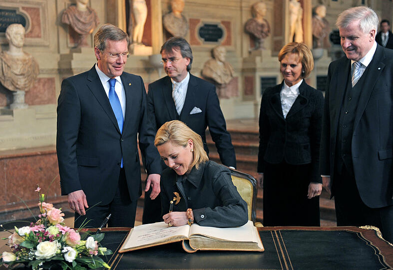 Sie macht das mit links: Bettina Wulff trägt sich ins Goldene Buch ein, Karin und Horst Seehofer (rechts) rücken in die zweite Reihe.