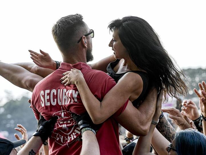 Lend a helping hand: Eine Feiernde wird von einem Sicherheitsmitarbeiter aus der Menge geborgen.