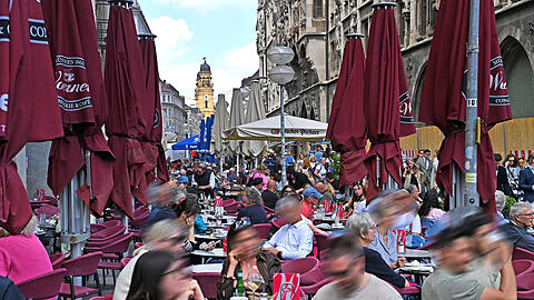 Viele M&uuml;nchner genie&szlig;en auch Regenpausen gerne im Freien, wie hier am Marienplatz.